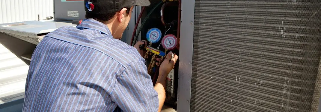 HVAC technician servicing a condenser unit in Brazil